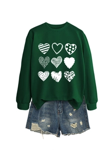 Detail of dark green sweatshirt with heart print and distressed denim shorts