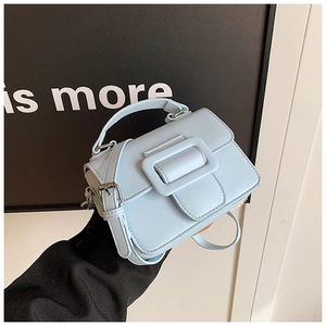 Dettaglio mini borsa a tracolla azzurra con una grande fibbia decorativa unica
