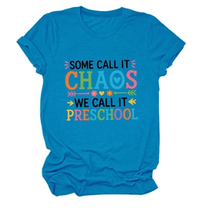 Détail d'un t-shirt bleu roi avec slogan 'Some Call It Chaos' et motifs de dessin animé