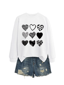 Detail of white crewneck sweatshirt featuring nine heart patterns and vintage denim shorts
