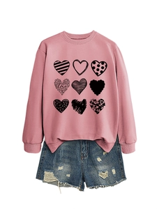 Detail of pink crewneck sweatshirt with nine black hearts and distressed denim shorts