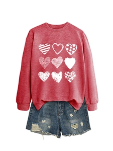 Detail of red crewneck sweatshirt with nine heart prints and distressed denim shorts
