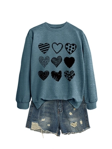Close-up of heart print sweatshirt with love design and distressed denim shorts detail