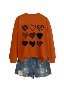 Close-up of orange crew neck sweatshirt with nine black heart prints and love typography