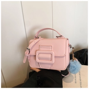 Dettaglio di una borsa a mano in pelle PU rosa con ciondolo di peluche e tracolla regolabile