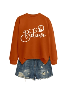 Detail of orange crewneck sweatshirt with Believe graphic and blue denim shorts