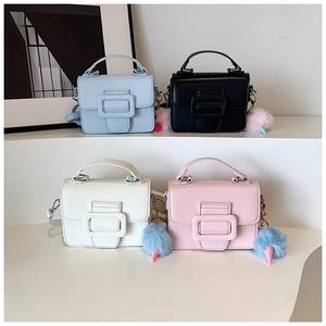 Dettagli mini borse a tracolla in blu, nero, bianco e rosa con ciondoli in peluche
