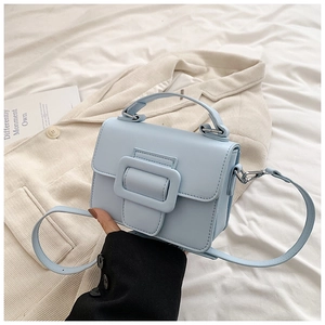 Dettaglio mini borsa quadrata azzurra in pelle PU opaca con manico e tracolla sottile