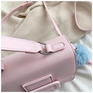 Dettaglio della borsa a tracolla in pelle PU rosa con pompon blu e anello in metallo argento