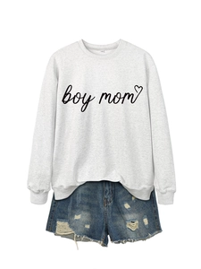 Detail of grey crewneck sweatshirt with boy mom text and distressed denim shorts