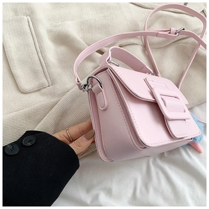 Dettaglio borsa quadrata rosa con fibbia decorativa e ciondolo di peluche colorato