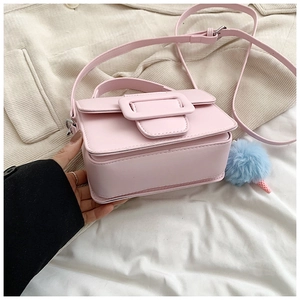 Dettaglio borsa quadrata rosa con fibbia decorativa e ciondolo in peluche blu soffice
