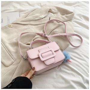 Dettaglio borsa rosa chiaro con fibbia in resina e ciondolo di peluche azzurro