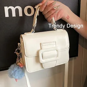 Borsa a mano bianca in ecopelle con grande fibbia e ciondolo con pompon blu morbido