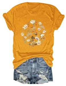 Flat lay of ginger yellow t-shirt with floral print and ripped denim shorts on white