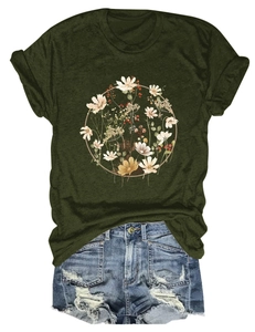 Flat lay of a forest green t-shirt featuring floral wreath print and distressed denim shorts
