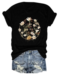 Flat lay of women's black T-shirt with floral wreath print and ripped denim shorts
