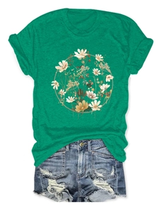 Flat lay of green t-shirt with floral wreath print and ripped denim shorts
