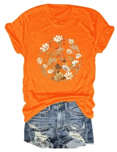 Detailed view of women's bright orange floral t-shirt paired with ripped denim shorts