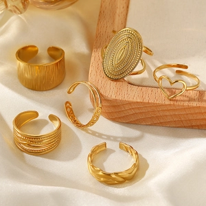Set of six adjustable 18K gold plated wide geometric stainless steel rings on white silk