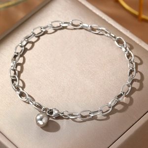 Elegant stainless steel link bracelet with round ball charm on champagne jewelry box