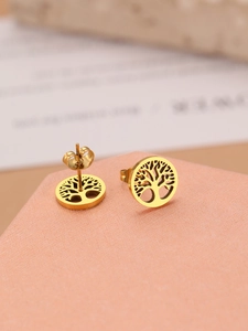 Macro view of gold plated tree of life stud earrings on a pink textured gift box