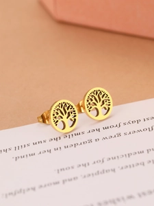Macro detail of gold tree of life stud earrings on a textured paper background