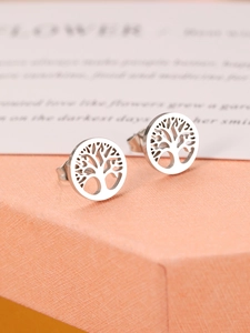 Detailed macro view of silver steel Tree of Life stud earrings on an orange gift box