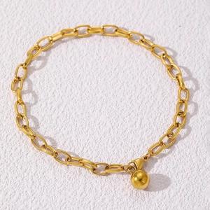 Detailed macro view of a gold-toned cable chain bracelet featuring a solid round bead pendant