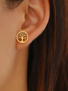 Close-up of golden Tree of Life earrings worn on ear, showcasing hollow design details