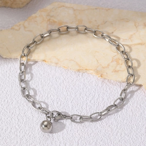 Macro detail of stainless steel bracelet featuring oval links and a polished spherical charm
