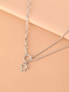 Detail of silver sun totem pendant with dual-style chain on minimalist display