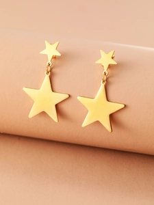 Macro view of gold-plated star tassel earrings with high-polish mirror finish detail
