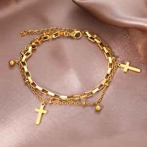 Detail of 18K gold-plated double-layer bracelet with cross pendant on pink silk