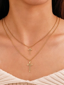 Close-up of double-layered gold cross necklace set worn on a white ribbed top