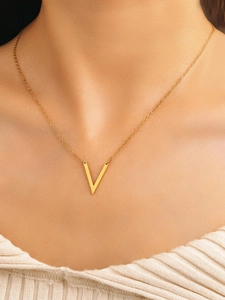 Nahaufnahme der goldenen V-Halskette an Model mit weißem Strickpullover für Damen
