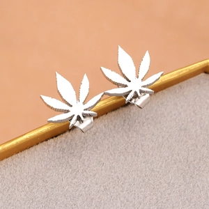Detailed macro view of silver leaf-shaped stud earrings with polished metallic finish