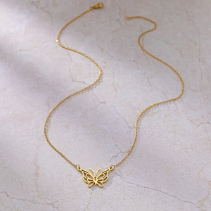 Vue détaillée d'un collier pendentif papillon ajouré avec une finition dorée polie