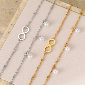 Detail view of double-layered stainless steel anklets with infinity charms and pearls
