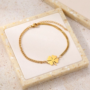 Close-up of gold clover bracelet with unique dual-chain design on a display tray