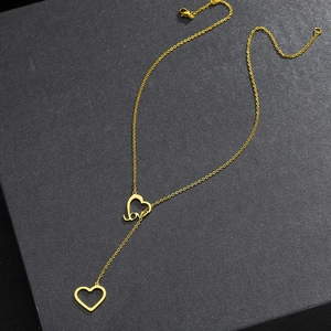 Close-up of golden Y-shaped necklace with heart pendants and Love letter engraving