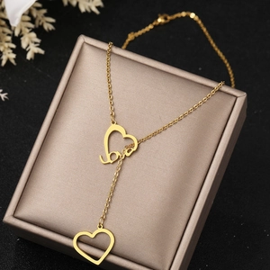 Elegant gold Y-shaped necklace with heart pendants and love script on a display box