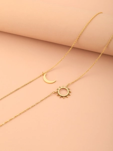 Detail of gold double-layered titanium steel necklace with sun and moon pendants