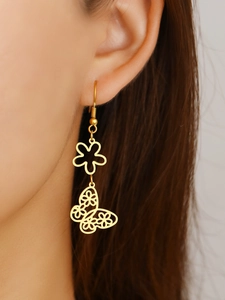 Close-up of elegant gold butterfly earrings with intricate cut-outs worn by a model