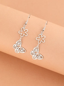 Detail of silver hollow butterfly drop earrings with floral texture on a display stand