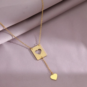 Minimalist gold heart cutout rectangle pendant necklace on soft lavender fabric background