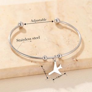 Minimalist stainless steel open bracelet with an airplane pendant and adjustable beads