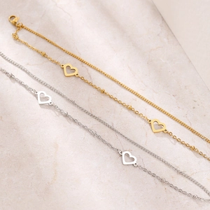Collane minimaliste con cuore traforato in oro e argento su fondo in marmo elegante