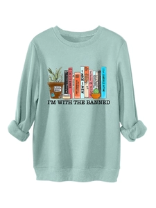 Dettaglio felpa verde menta con stampa letteraria 'I'M WITH THE BANNED' sui libri