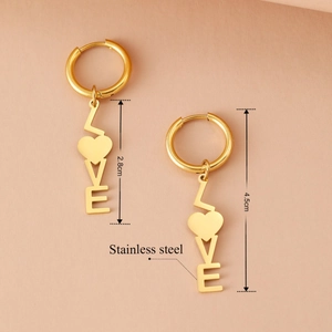 Vintage goldene LOVE Buchstaben-Ohrringe aus Edelstahl für Damen auf beigem Hintergrund